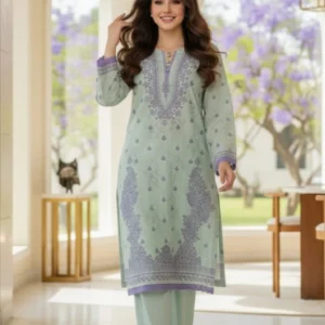A Pakistani woman wearing a Sairi Wardrobe Mint Green and Lilac stitched 2-piece Lawn suit. The outfit features a mid-length straight Lawn shirt with purple floral embroidery on the neckline and daman, paired with matching seafoam green straight-fit Lawn trousers. Perfect for ready-to-wear summer fashion in Pakistan.